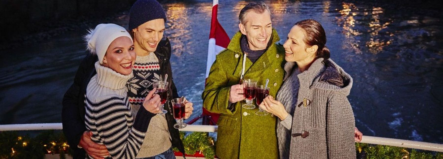 Vier Personen mit Punsch an Deck eines Schiffs