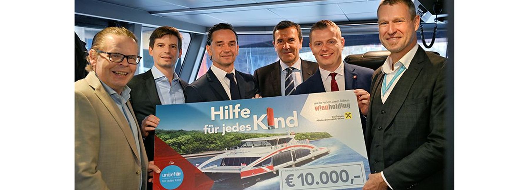 Sechs Personen halten einen Riesenscheck