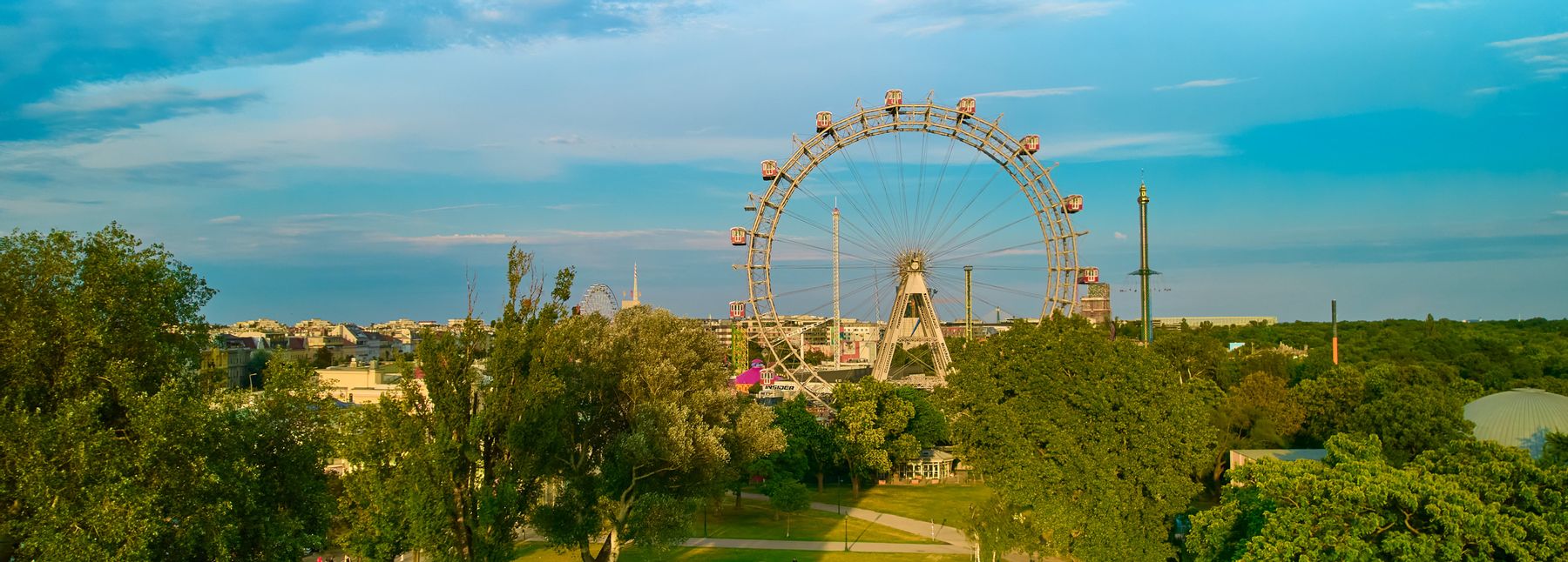 Panoramablick über den Prater in Wien mit dem Riesenrad und zahlreichen Bäumen.