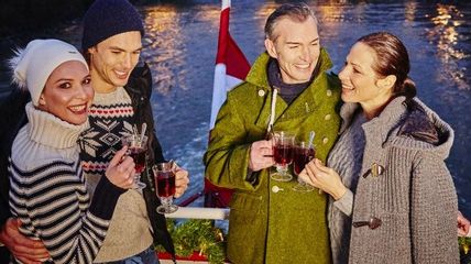 Vier Personen mit Punsch an Deck eines Schiffs