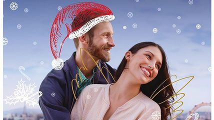 Zwei Personen, eine mit gemalter Weihnachtsmütze, eine mit gemalten Flügel