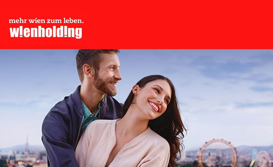 Newsletter-Sujet der Wien Holding mit rotem Balken und Wien Holding-Logo oben und unten; Panoramablick auf Wien mit dem Riesenrad im Hintergrund, im Vordergrund umarmen sich ein Mann und eine Frau.  